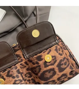 Close-up of leopard print suede texture and golden metal magnetic buckle on bag