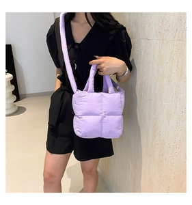 Détail d'un sac cabas matelassé violet avec poignées et bandoulière amovible