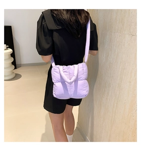 Vue arrière du sac bandoulière matelassé violet clair porté par un mannequin en noir