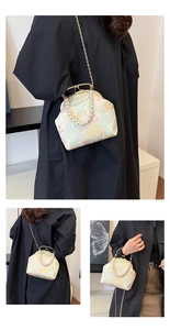 Detalle de bolso bordado chino con asa de perlas y cierre de metal de estilo vintage