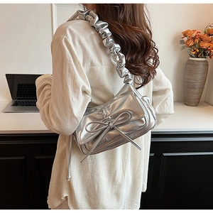 Silver PU leather underarm bag with bow decoration and pleated shoulder strap on model