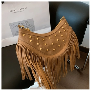 Détail du sac à franges en daim marron avec rivets dorés et structure en demi-lune