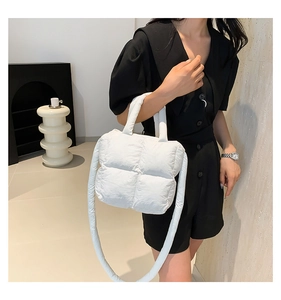 Gros plan sur un sac matelassé blanc style doudoune avec poignée souple et bandoulière