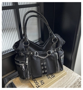 Close-up of gothic punk tote bag with silver metal chains and decorative rivets