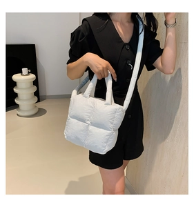 Détail d'un sac matelassé blanc avec bandoulière rembourrée et style moderne épuré