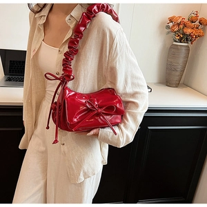 Sac à bandoulière en cuir verni rouge avec nœud 3D et bandoulière plissée élégante