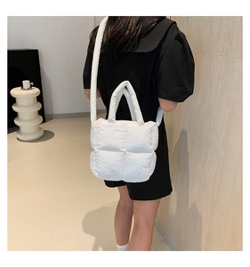 Vue détaillée du sac matelassé blanc avec bandoulière rembourrée et poignée supérieure souple