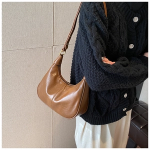 Detailed side view of dark brown hobo bag with adjustable strap and gold hardware