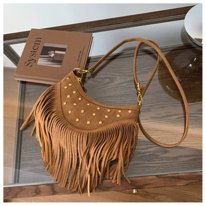 Détails du sac bandoulière en daim marron avec clous dorés et longues franges en cuir