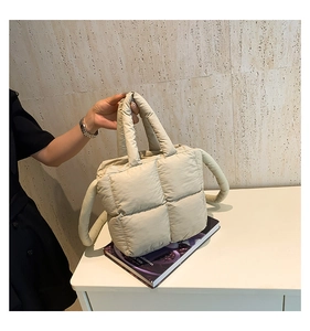 Détail du matelassage carré sur le sac fourre-tout rembourré de couleur beige