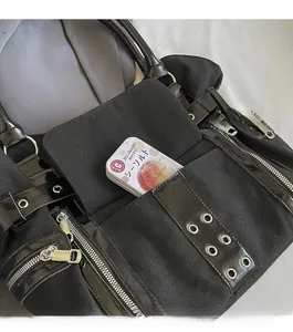 Detail of the punk canvas tote bag showing the functional front pocket with metal eyelets