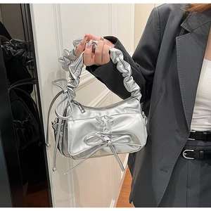 Détail du sac à main en PU argenté avec poignée plissée et décoration de nœud