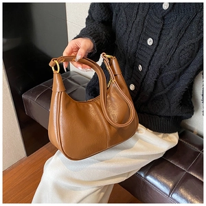 Close-up of the stylish brown hobo bag showing its leather texture and gold hardware details