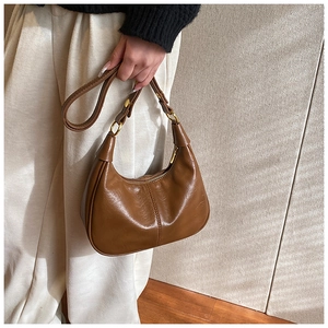 Brown polished leather hobo shoulder bag with crescent shape and gold hardware