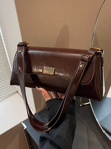 Dark brown glossy patent leather shoulder bag with vintage gold buckle closure