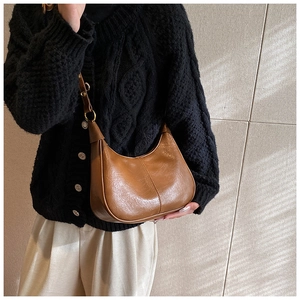 Detailed view of brown hobo bag with gold hardware and contrast stitching for daily wear