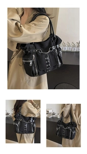 Detail of gothic punk tote bag showing multi-zipper pockets and metal chain accents