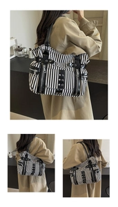 Detail view of gothic punk canvas tote with black stripes, rivets and silver metal chains