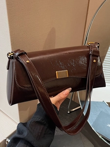 Retro chocolate brown glossy underarm bag with gold buckle in a stylish handheld view