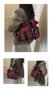 Detail of red plaid punk tote bag with metal chains, silver eyelets and multiple zippers