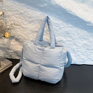 Sac rembourré bleu clair minimaliste avec bandoulière large et texture souple douce