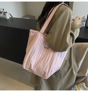 Detailed side view of large pink pleated canvas tote bag with kiss yourself fabric label