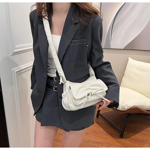 Détail du sac à épaule en similicuir crème avec texture plissée et nœud décoratif élégant