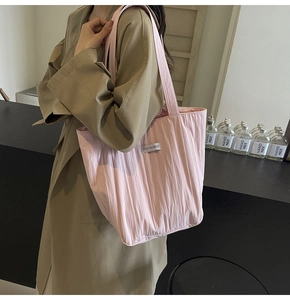 Detail view of pink quilted shoulder bag featuring vertical stitching and woven label