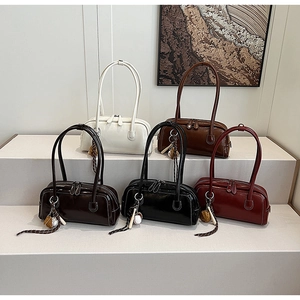 Detail of Boston baguette bags in five colors with glossy finish and sports ball charms
