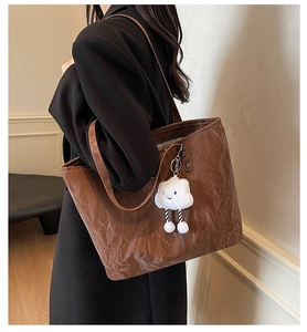 Detail of dark brown retro tote bag with unique pleated texture and cloud charm