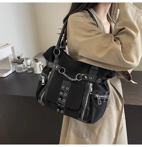 Gothic punk tote bag in black canvas with silver chains shown in a trendy cafe setting