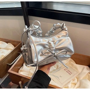 Détail d'un sac à main argenté en PU avec des nœuds et une poignée supérieure plissée
