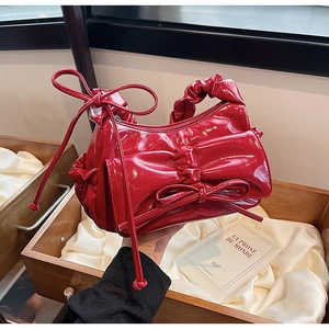 Détail du sac à main rouge brillant en PU avec plis élégants et grand nœud décoratif