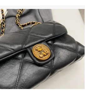 Gros plan d'un sac en cuir noir matelassé avec boucle dorée en relief d'ours