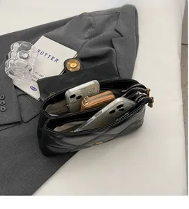 Détail du sac matelassé noir avec deux compartiments intérieurs pour téléphone et monnaie