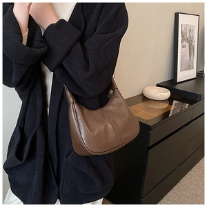 Side view of dark brown vintage oil-waxed leather hobo bag with vertical stitching