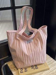 Pink quilted tote bag with pleated texture and shoulder straps for daily casual use