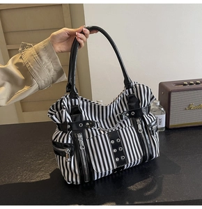 Detail of gothic punk canvas tote with black and white stripes and silver metal chain