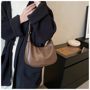 Detail view of dark brown matte leather hobo bag with adjustable strap and pleated texture