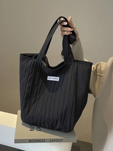 Large black pleated canvas tote bag with shoulder straps and white kiss yourself label