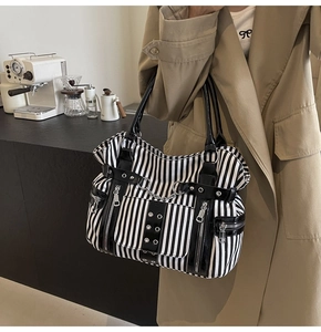 Detail of gothic punk tote with vertical stripes, metal chains and rivet accents