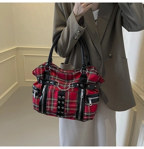 Detail of red plaid tote bag with silver chains and metallic punk zipper accents