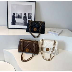Détail de sacs en cuir matelassé noir, marron et blanc avec bandoulière dorée