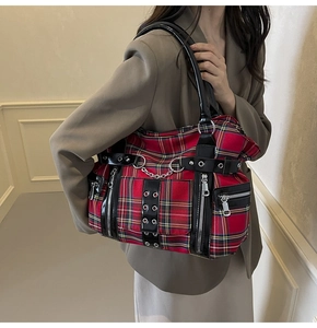Close-up of red plaid canvas tote bag with punk metal chain and zipper details