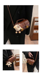 Détails du sac cylindre marron foncé avec boucle dorée et breloque mouton en peluche
