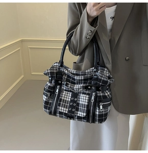 Detailed view of the punk plaid tote bag with silver chains and metallic rivets detail