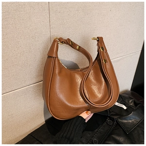 Detail of a brown crescent shoulder bag featuring gold hardware and oil wax leather