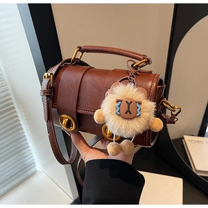 Vue détaillée du sac à main vintage en cuir marron avec fermoir rotatif anneau doré