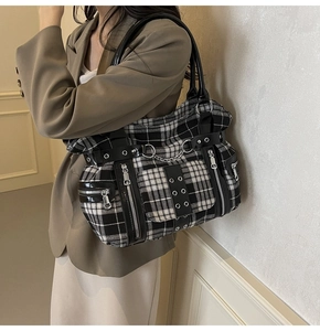 Detail of gothic punk tote bag with black and white check pattern and metal zipper chains