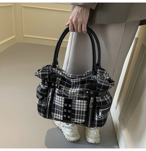 Detail of checkered gothic punk tote bag with silver metal chains and rivets decoration